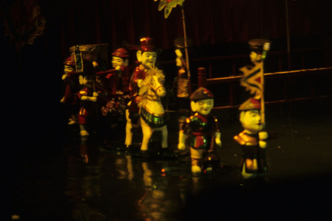 Close-up view of colorfully painted water puppets performing in Hanoi