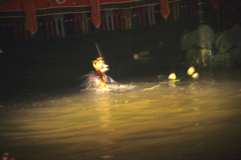 A water puppet appears near lily pads at a performance in Hanoi