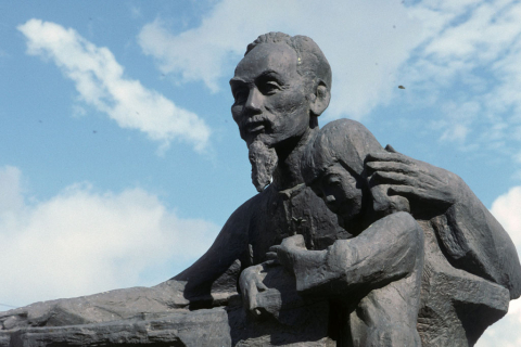 Stone statue in Hanoi of Ho Chi Minh reading to young girl