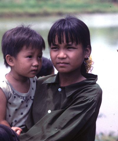 Highland girl holds younger child in rural area between Mai Chau and Ninh Binh