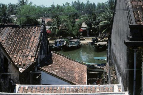 View over houses into harbor with fishing boats at Hoi An