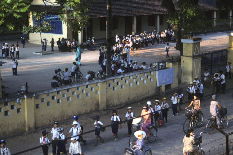 Lines of children in uniforms walk out of school ground in Danang