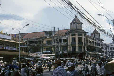 Chinatown market buildings with balconies and shoppers in Ho Chi Minh City