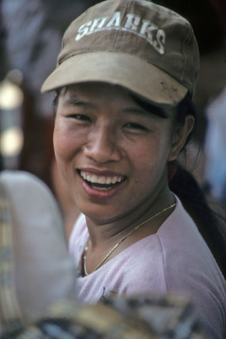 Portrait of laughing young Vietnamese woman wearing a Sharks baseball cap