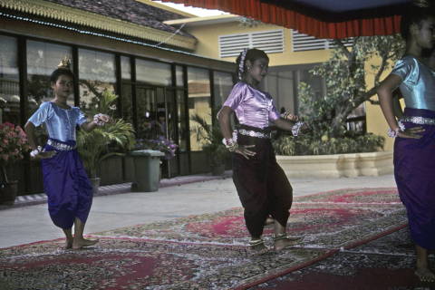 Three female palace dancers wearing silk costumes perform in Phnom Penh