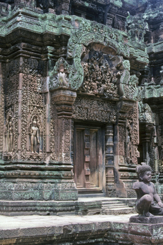 Ornately carved central tower entrance at Banteay Srei Temple with guardian statue