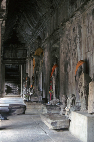 Inner temple hallway lined with stone statues including Buddha at Angkor Wat