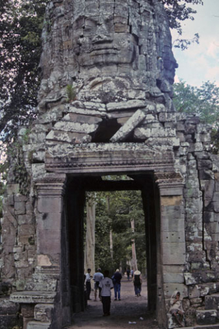 Face tower with broken lintel over stone doorway at Ta Prohm