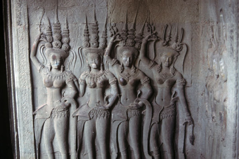 Carved relief of four dancing female divinities with spiked crowns at Angkor Wat