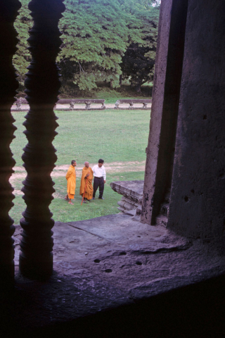 Three men including two Buddhist monks seen through doorway at Angkor Wat