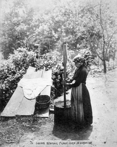 Woman pounding corn