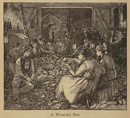 People sitting around a large pile of corn and husking corn cobs.